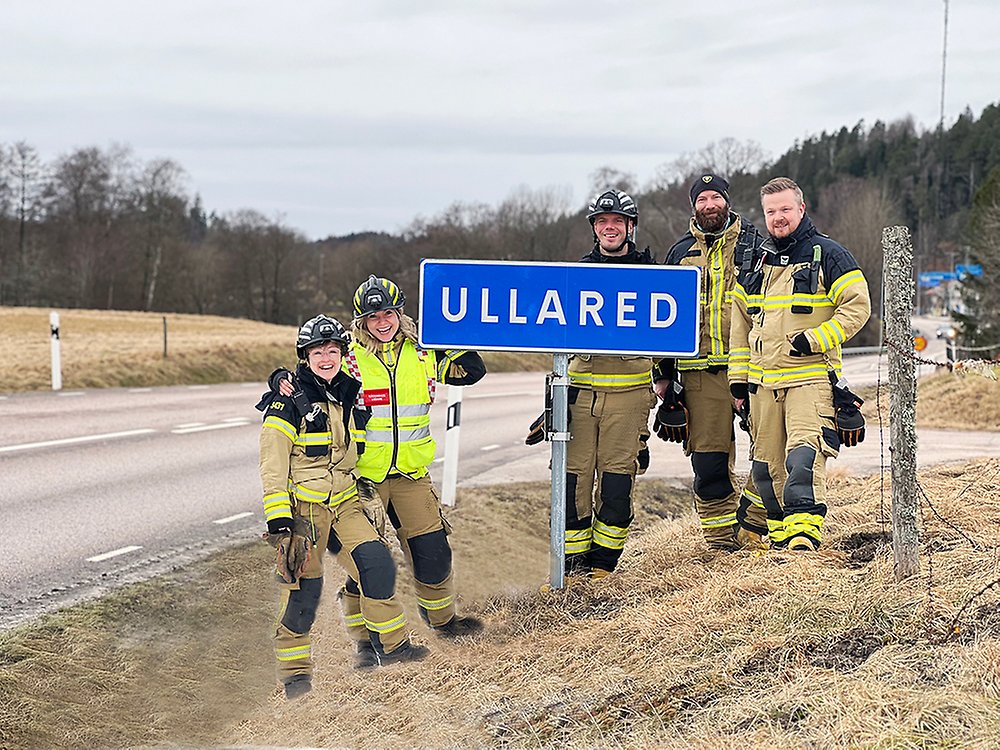Fem brandmän står vid en skylt där det står Ullared på.